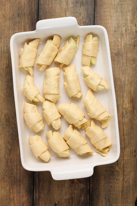 Apple slices wrapped in crescent roll dough arranged in a white baking dish Apple Slice Crescent Rolls, Cressant Rolls, Cresant Rolls, Best Fall Desserts, Baked Apple Slices, Easy Apple Dumplings, Baked Apple Recipes, Sliced Apples, Potluck Desserts