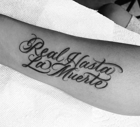 Real Hasta La Muerte ✨ forearm tattoo with lettering in Spanish Hand Tattoos In Spanish, Tats In Spanish, Mexican Word Tattoo, Cursive Spanish Tattoos, La Vida Es Fria Tattoo Design, La Lettering Tattoo, Spanish Cursive Tattoo, Spanish Lettering Tattoos, La Tattoo Lettering