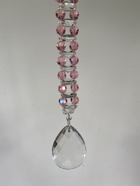 "Ladder  design with flat \"saucer\" clear crystals and round pink crystals.  Hanging on bottom is a big (50 mm long) clear faceted glass prism. Overall length is about 8 inches. This shining sun catcher reflects sunlight that passed through it making specks of light on the walls.  Best hanging in front of  a window, from a lamp or light, or in a sunroom or porch. Attached is a 24-inch super strong thread that is easily adjustable." Hanging Crystals Diy, Suncatchers Diy, Crystal Suncatchers Diy, Crystals Hanging, Suncatcher Diy, Ladder Design, Wine Bottle Centerpieces, Glass Prism, Hanging Items