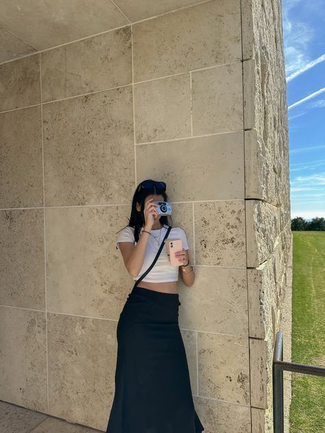 a girl leaning on a building taking a  photo. her camera is covering her face and she is wearing a white crop top and a long black skirt Black Museum Outfit, Cross Body Bag Outfit Summer, Black Cross Body Bag Outfit, Crossbody Bag Outfit Summer, Museum Outfit Spring, Buenos Aires Outfit Summer, Summer Museum Outfit, Ootd Museum, Black Long Skirt Outfit