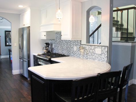 The curved peninsula in this transitional kitchen creates the perfect eat-in bar. The white and black cabinets and gray backsplash create an elegant feel in the space. The rich wood floors also allow this kitchen to feel warm and inviting. Peninsula Kitchen Ideas, White Traditional Kitchen, White Transitional Kitchen, Peninsula Kitchen, Curved Kitchen Island, Curved Kitchen, Kitchen Peninsula, Grey Backsplash, Storage Inspiration