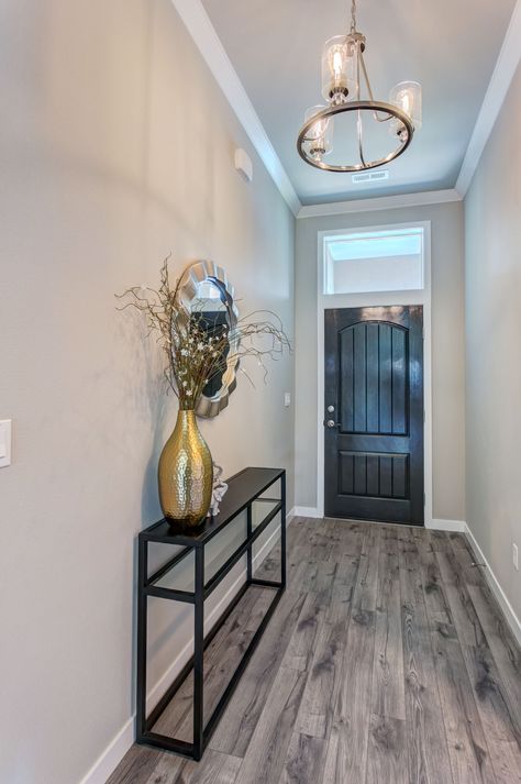 Compact entryway with plenty of style. Grey-tone laminate flooring, warm grey walls, and a classic light fixture. Rustic Grey Flooring, Light Grey Walls With Grey Floors, Light Grey Walls Grey Floors, Floors For Grey Walls, Grey Flooring Paint Colors, Floors And Walls Combination, Grey Laminate Flooring Living Room Decor, What Color Floors Go With Agreeable Gray, Flooring For Grey Walls