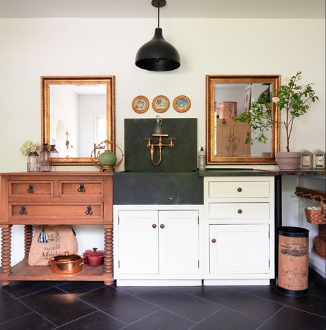 White kitchen cabinets with black soapstone sink and counter. Vintage wood butcher block counter to the left. Mirrors and gold art as backsplash. Soapstone Sink, Spring Village, Soapstone Kitchen, Cold Spring Ny, Soapstone Countertops, Rocking Chair Porch, Eclectic Living, Vintage Farmhouse Kitchen, Rustic Bathrooms