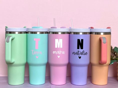 Personalized 40 Oz Metal Tumbler with Handle All Tumblers include a Lid & a Clear Plastic Straw Available in 5 Pastel Colors All Designs are made with High Quality Vinyl Designs.  ‼️ HAND WASH ONLY‼️ ORDERING INSTRUCTIONS -Enter your desired text into the personalization box  (‼️12 CHARACTERS MAX)   THINGS TO CONSIDER: -Longer texts may result in smaller looking texts than shorter texts.  -Always double check your spelling.  -Please double check your shipping address. We will not be responsible Tumbler Cups Vinyl, Custom Tumbler Cups Vinyl Decals, Metal Tumbler, Cup With Lid And Straw, Straw Tumbler, Metal Tumblers, Custom Tumbler Cups, Tumbler With Handle, Trendy Gifts