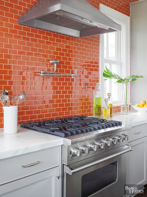 Instead of hanging upper cabinets, these homeowners refreshed their kitchen's outlook with glossy, light-reflective orange subway tiles running from the countertops to the ceiling. Each row of tiles is offset from adjacent rows to create a brick or running bond pattern, which brings a sense of movement to expansive tile installations. Backsplash Herringbone, Creative Backsplash, Orange Kitchen Decor, Farmhouse Backsplash, Orange Tiles, Beadboard Backsplash, Herringbone Backsplash, Orange Kitchen, Backsplash Designs