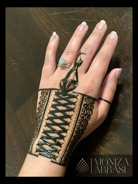 Henna art drawn out to look like a corset. There are ribbons that are intertwined in a crisscross pattern and tied in a bow with ribbons flowing down the middle finger Lace Glove Tattoo, Lace Hand Tattoo, Henna Glove, Practice Henna, Black Lace Tattoo, Corset Tattoo, Hena Designs, Henna Inspo, Circle Mehndi