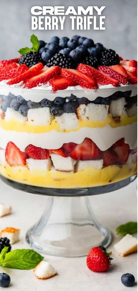 A berry trifle with layers of pudding, angel food cake, white chocolate pudding, whipped cream, and berries in a trifle dish. Trifle With Pound Cake, Red White And Blue Trifle, Angel Food Cake Trifle, Berry Trifle Recipe, Trifle Bowl Recipes, Trifle Dessert Recipes, Cheesecake Trifle, Berry Trifle, Trifle Dish