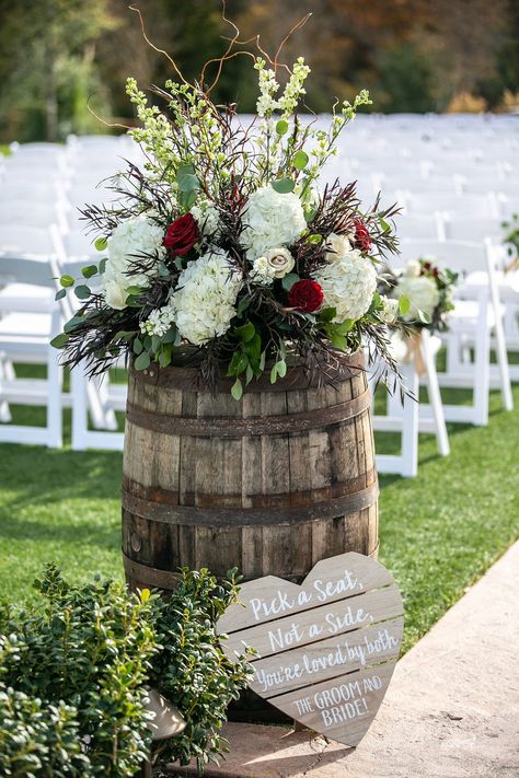 | wedding ceremony decor | modern rustic outdoor wedding ceremony decoration ideas | wedding ceremony barrels with flowers on top | red + white wedding decorations | rustic wedding ceremony sign | rustic outdoor wedding | photo taken at THE SPRINGS Event Venue. follow this pin to our website for more information, or to book your free tour! SPRINGS location: Tuscany Hill in McKinney, TX photographer: Randall Stewart Photography #weddingdecor #weddingceremony #rusticwedding #weddingflowers #dfw Red And White Wedding Decorations, Ceremony Decorations Outdoor, Wedding Ceremony Decorations Outdoor, White Wedding Decorations, Rustic Wedding Decorations, Rustic Wedding Ceremony, Wedding Ceremony Signs, Rustic Outdoor Wedding, Rustic Wedding Signs