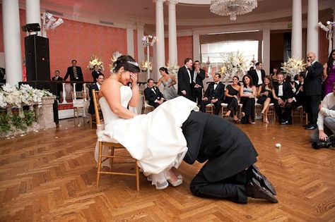 the bride looking embarrassed sitting in a chair while the groom is taking off her garter - photo by Houston based wedding photographer Adam Nyholt Wedding Photo List, Dresses Photography, Black Garter, Wedding Photo Gallery, Wedding Expenses, Bouquet Toss, Christmas Porch Decor, Vintage Romance, Wedding Inspiration Board