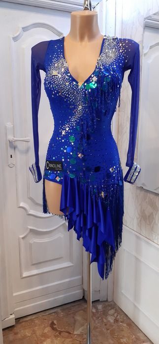 Rhinestones, acrylic sew-on mirrors, large crystals, sequins, beaded fringe...this Latin dress has quite a variety of sparkly decorations. There is a small triangle skirt yoke attached to the leotard, with ruffles attached at a diagonal angle. The sleeves are blue mesh, with rhinestone bracelets to go with the dress. Sparkly Decorations, Fringe Inspiration, Skirt Yoke, Triangle Skirt, Latin Competition Dress, Ballroom Dress Inspiration, Dancesport Costume, Mirrored Costume, Ballroom And Latin