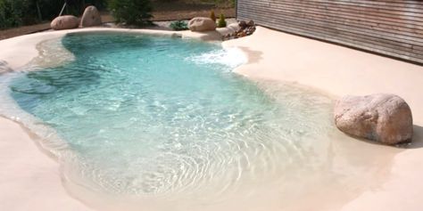 Instead of installing traditional pools for some backyard fun in the sun, people are creating their own sandy beaches! Sand Pool Ideas, Beach Entrance Pool Designs, Small Beach Pools Backyard, Sand Pools Backyard, Pool Beach Ideas, Faux Beach Backyard, Small Beach Entry Pool, Sand Pool Backyard, Beach Pools Backyard