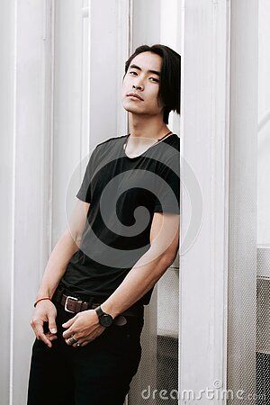 Asian Male Model Posing, Confident Look, Leaning Against The White Wall, Hand On The Belt, Long Dark Haircut, Wearing Black T- Stock Photo - Image of chinese, model: 217303814 Up Against Wall Pose, Guy Leaning Against Wall Reference, Male Leaning Against Wall Pose Reference, Lean Against Wall Pose, Long Dark Haircut, Leaning Against Door Frame Pose, Guy Leaning Against Wall, Leaning On Wall Pose Reference, Leaning On Wall Pose