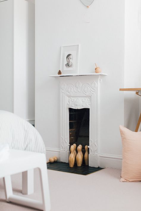 White Victorian cast iron fireplace | Wooden skittles | Illustrative prints | A modern neutral millennial pink bedroom for children with handmade furniture, personalised artwork and statement lighting Painted Cast Iron Fireplace, White Victorian Fireplace, Victorian Fireplace Bedroom, White Cast Iron Fireplace, Bedroom Fireplace Victorian, Small Bedroom Fireplace, Cast Iron Fireplace Bedroom, 1920 Bedroom, Victorian Bedroom Fireplace