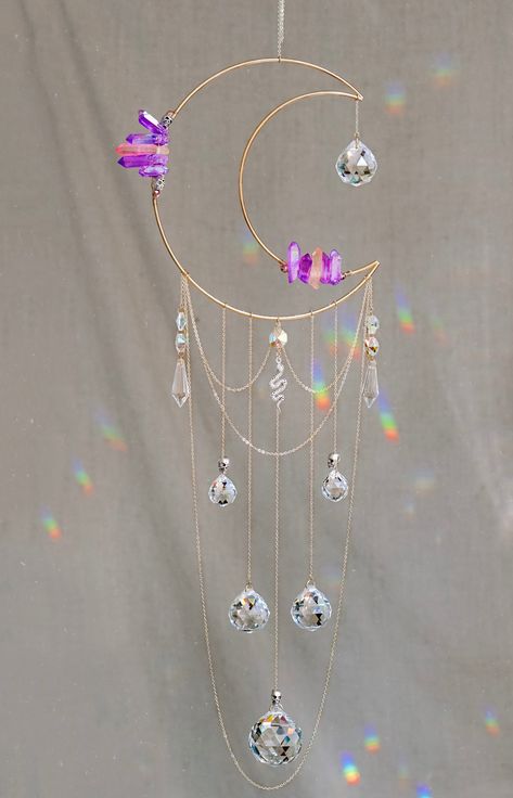 This magical rainbow-maker is handcrafted with gold-plated chain, dyed titanium-infused quartz, six prisms of varying sizes, iridescent hexagonal beads, beaded skull details, and a silver serpent charm. Hang these in your windows or any place in your space that gets a lot of sunlight to drench your space in beautiful, colorful rainbows! Each golden moon is accentuated with drips of different-sized crystal prisms and secured with gold plated chain. The Details: 8" Moon // Entire piece roughly 30" Crystal Suncatchers Diy, Moon Suncatcher, Goddess Moon, Suncatcher Diy, Moon Rainbow, Golden Moon, Magical Rainbow, Bead Crochet Patterns, Cute Couple Gifts