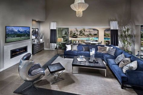 This metallic blue sofa might be in a cool color, but the sheer size makes it perfect for filling this enormous space. Note that the furniture is pushed away from the walls, and plants are used to fill open space between the back of the sofa and the wall. Blue Sectional Living Room, Black And Silver Living Room, Living Room With Ottoman, Silver Living Room Decor, Blue Grey Living Room, Silver Living Room, Sectional Living Room, Grey Wall Color, Gray Living Room Design