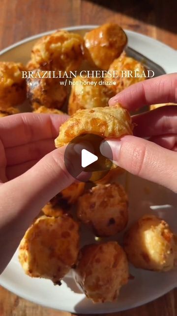 Global Cuisine Traveler on Instagram: "🇧🇷 Origin: Brazilian cheese bread, known as "pão de queijo," is a popular snack originating from Brazil. These delicious cheese bread balls are gluten-free and made with tapioca flour, giving them a unique chewy texture. 🧀

Serving: Makes about 24 cheese bread balls

Ingredients:
- 2 eggs
- 2/3 cup (160ml) olive oil
- 2 1/2 tsp salt
- 1 1/2 cup (360ml) milk
- 1 cup (100g) cheese of choice (cheddar, mozzarella, etc.), shredded
- 1/2 cup (50g) Parmesan cheese, grated
- 3 cups (360g) tapioca flour

For the hot honey drizzle:
- 1/4 cup (60ml) honey
- 1-2 tbsp hot sauce (adjust to taste)

Instructions:
1. Preheat your oven to 375°F (190°C). Line a baking sheet with parchment paper.
2. In a blender, combine eggs, olive oil, salt, milk, cheeses, and tapio Cheese Bread Balls, Bread Balls, Brazilian Cheese Bread, Honey Drizzle, Popular Snacks, Tapioca Flour, Hot Honey, Global Cuisine, Cheese Bread