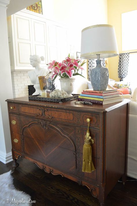 While painted furniture is still incredibly popular, don't overlook the beauty of dark wood.  We used this vintage dresser as a grounding point in a living room filled with white slipcovered furniture, and it provides a wonderful contrast (plus, those drawers are oh-so-useful for storing table linens).  Then we hit HomeGoods for everything we needed to style the top--a blue and white lamp, tray, apothecary jar, plaster bust, and more--and make it a functional and beautiful focal point {sponsored Vintage Dresser In Living Room, Painted Furniture In Living Room, Styling Dark Furniture, Vintage Living Room Decor Antique, Decorating With Dark Wood Furniture, Dressers In Living Room Ideas, Dresser In Living Room Decor, Dressers In Living Room, Dark Wood Living Room Furniture