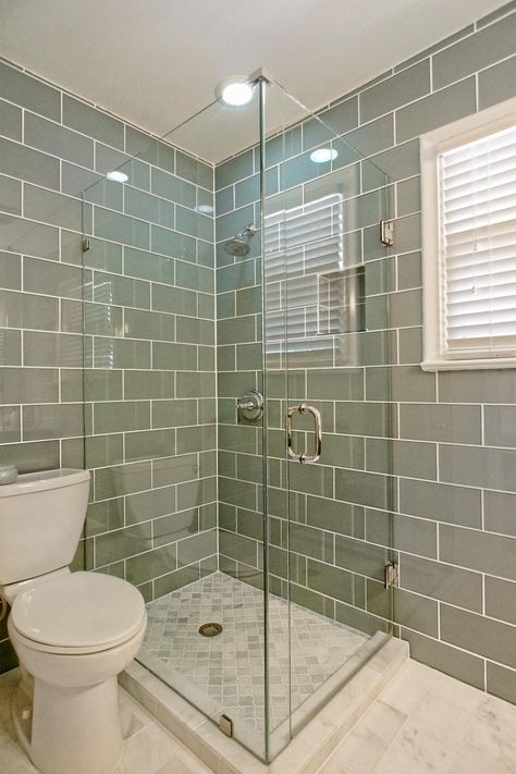 This sleek master bathroom features a glass enclosed shower paired with gray tiled walls. Gray and white marble floors offer a finishing touch. Glass Enclosed Showers, Grey Bathroom Tiles, Marble Floors, Bathroom Features, Storage Inspiration, Bathroom Images, Transitional Bathroom, Shabby Chic Bathroom, Bathroom Tile Designs