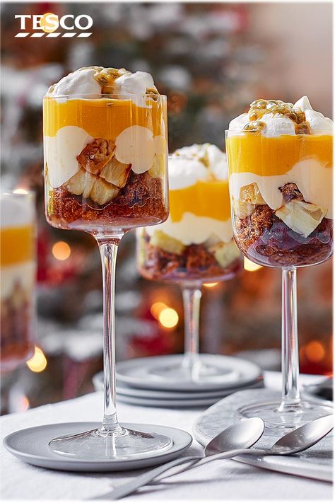 Finish off Christmas dinner with this tropical trifle recipe for something a little different. With layers of ginger wine-soaked ginger cake, roasted pineapple and sweet mango, this easy trifle recipe is sure to impress. | Tesco Trifle Cake Layered, Trifle Food Photography, Tropical Trifle Desserts, Tropical Christmas Dinner, Summer Christmas Dessert, Christmas Dessert Ideas Easy, Tropical Trifle, Easy Trifle Recipe, Desserts For Christmas