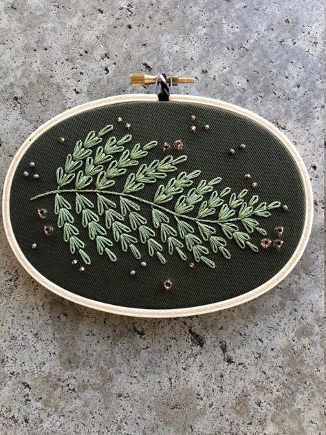 This embroidery was inspired by ferns, which I encounter every day here in the Pacific Northwest. I hand-embroidered a detailed and textured fern frond and added beaded details around the outside, for even more texture and a little bit of shine. I really love this design and think it would fit in with a lot of home decor styles. - framed in a 3x5 inch wooden hoop- hand embroidered design and hand beaded details- embroidered on cotton blend fabric- back is covered in a decorative piece of fabric Pnw Embroidery, Goth Embroidery, Fern Embroidery, Nature Embroidery, Floral Minimalist, Painted Clothing, Embroidery Leaf, Fern Frond, Hand Painted Clothing