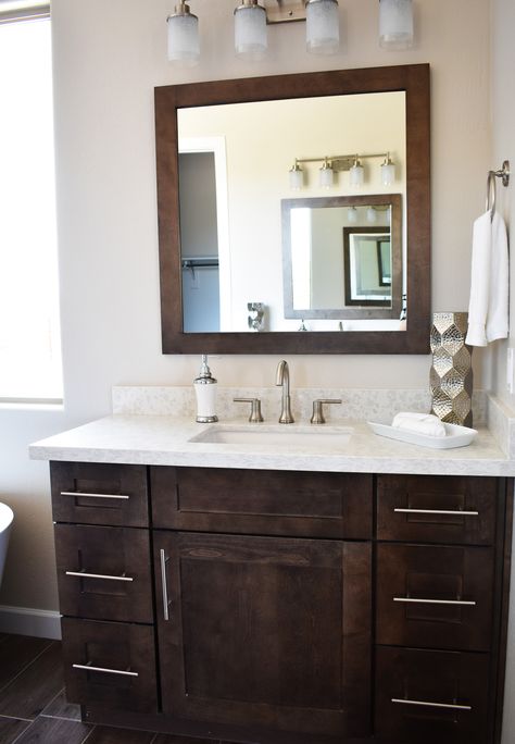 This is a feature photo of one of two vanities in this master bathroom. These home owners selected a dark wood shaker style cabinet, stainless steel hardware pulls, and a matching framed mirror. Home built by Morgan Taylor Homes in Scottsdale, AZ. Dark Brown Mirror Bathroom, Bathroom Vanity Dark Wood, Bathroom With Dark Wood Cabinets, Dark Oak Bathroom Vanity, Bathrooms With Dark Cabinets, Dark Brown Vanity Bathroom, Dark Wood Bathroom Cabinets, Dark Brown Bathroom Cabinets, Masterbathroom Ideas