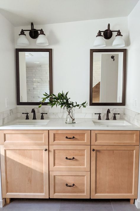 This bathroom remodel includes his and her sinks with generous and efficient drawer storage! The warm wood vanity is light enough to create an open and airy feel without going stark and sterile, and the dark fixtures add a touch of masculinity to an otherwise light and feminine room. We hope this gives you some decor ideas! Light Wood Bathroom Vanity, His And Hers Bathroom, His And Hers Sinks, Bathroom Design Decor, Boys Bathroom, Bathroom Decor Ideas, Upstairs Bathrooms, Bathroom Update, Wood Vanity