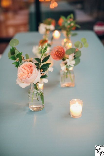 Orange and Blue Coastal Wedding | Small Bud Vases Centerpieces | Designed by Engaging Events Wedding Flowers In Small Vases, Flowers For Small Vases, Flowers In Tiny Vases, Small Floral Vase, Table Centerpiece For Engagement Party, Small Bud Vases Wedding Table, Small Floral Table Centerpiece, Flower With Candle Centerpiece Ideas, Small Bridal Shower Flower Arrangements