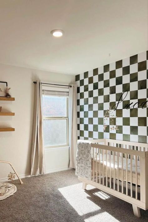 This delightful nursery showcases a light wood crib standing gracefully against a captivating black and white checkered accent wall. Stained wood floating shelves adorn the wall above a cozy beige baby play mat. Infuse warmth and light into the room with beautiful white-framed windows dressed in beige curtains. Checkered Accent Wall, Light Wood Crib, Checkered Nursery, Geometric Accent Wall, Wood Crib, Nursery Accent Wall, Kids Rooms Inspo, Accent Wall Ideas, Beige Baby