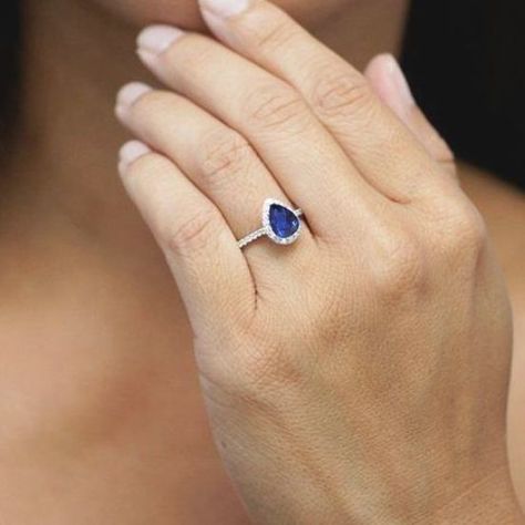 Pear shaped (teardrop) engagement ring ideas: classic platinum blue sapphire with halo. //  // #engagementrings #diamond #diamondrings #pearshapedengagementring #uniqueengagementrings #pearcut #platinumengagementrings Halo Ideas, Teardrop Engagement Ring, Engagement Ring Ideas, Blue Engagement Ring, Ring Sapphire, Classic Wedding Rings, Teardrop Ring, Sapphire Engagement Ring Blue, Pear Engagement Ring