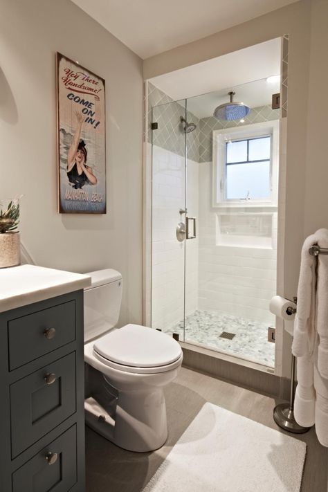 The+bathroom+off+the+man+cave+has+the+same+light+and+airy+feel+as+the+rest+of+the+house,+but+with+a+few+subtle+masculine+touches,+including+a+dark+gray+vanity+and+retro+artwork.++ Tile Walk In Shower, Masculine Bathroom, Condo Bathroom, Large Shower Heads, House Bathrooms, Storage Inspiration, Gray Vanity, Downstairs Toilet, Retro Artwork