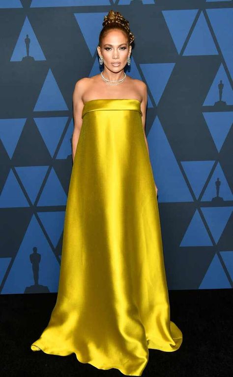 Singer and actress Jennifer Lopez strikes a pose and shows a fierce face while wearing a strapless yellow mustard gown at the 2019 Governors Awards in Los Angeles. Mustard Gown, J Lo Fashion, Gown Red Carpet, Golden Gown, Oscars 2014, Mustard Dress, Fashion Highlights, Yellow Gown, Celeb Fashion