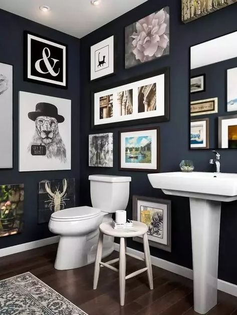 a navy bathroom with a gallery wall that takes all the blank wall space, white appliances and a mirror integrated into this art spot Small Bathroom Gallery Wall, Interesting Walls, 60s Bathroom, Bathroom Gallery Wall, Navy Bathroom, Paint Walls, Luxury Bathroom Master Baths, Dark Bathrooms, Restroom Design