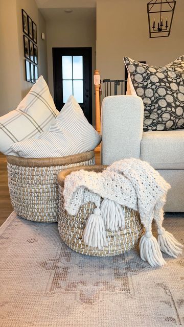 Logan Maggio | Home Decor Inspo + DIY on Instagram: "A simple way to create a cozy space is adding large baskets with pillows and throws. This set is from @305decoliving and I’m obsessed 🙌🏼 Follow my home journey on Instagram @JustAnotherWhiteHouse Curious where something is from? You can find links to my home on the free LTK app! Follow @JustAnotherWhiteHouse for exclusive app only content 🤍 #livingroom #livingroomdecor #cozy #cozydecor #cozyhome #cozyhomes #cozylivingroom #livingroominspira Living Room Throw Basket, Basket With Pillows Living Rooms, Throw Baskets Living Rooms, Basket With Blankets Living Rooms, Large Basket Decor Ideas, Floor Basket Decor Ideas, Apartment Decor Bathroom, Christmas Decorating On A Budget, Blanket Storage Living Room