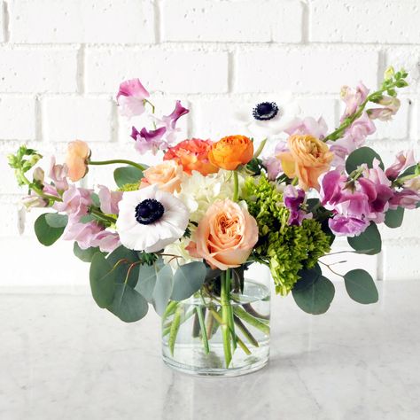 A beloved member of our playful lineup, the Cheyenne boasts a unique fusion of striking Anemone, Ranunculus, and soft peach Roses, paired with either fragrant lavender Snapdragons or Stock, and topped off with delicate Sweet Peas or Astilbe. Comes in a sleek glass cylinder or vibrant Teal Miguel. Our arrangements are named after streets in the metro. Cheyenne Lane is a quiet residential street in Mendota Heights. Cheyenne tribe of indigenous people of the great plains and we acknowledge that the Anemone Bouquet, Small Flower Arrangements, Ceramic Store, Flower Business, Glass Cylinder, Flower Arrangements Diy, Fresh Flowers Arrangements, Vase Arrangements, Sweet Peas