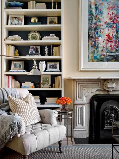 Traditional living room boasting a white built-in bookcase with black paint on the back creating a contrasting appeal showcasing books and fine decor. Ibb Design, Wooden Desk Chairs, Black Bookcase, Living Room Built Ins, Herringbone Wood Floor, White Bookshelves, Bookcase Styling, Bookcase Design, Bookcase Decor