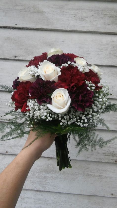 Rich colored bridal bouquet of burgundy and deep purple carnations, cream roses and baby's breath Maroon And White Flower Bouquet, Wine And White Wedding Bouquet, Colorful Mini Bouquet, Wine Red Flower Bouquets, Burgundy Carnation Bouquet, Burgundy And White Bridal Bouquet, Burgundy Bride Bouquet, Bride Bouquets Red, Rose And Carnation Bouquet