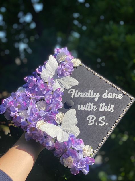 graduation cap design with purple & white flowers, white butterflies, pearls, “finally done with this BS” quote, bachelor’s of science, exercise science, kinesiology Done With This Bs, Finally Done With This Bs Graduation Cap, Grad Cap With Butterflies, Pearl Graduation Cap Ideas, Graduation Cap Designs Kinesiology, Graduation Cap With Butterflies, Cap Decoration Graduation Butterfly, Graduation Cap Designs With Butterflies, Purple Cap Decoration Graduation