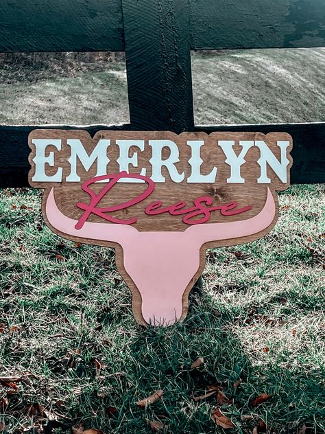 "This Longhorn Baby Name sign can be customized for your little cowgirl or cowboy. If you love the Rodeo Style decor this Bullhorn nursery baby sign is perfect for any kid's room. Customize the stain color for the baker and customize the first, middle and bullhead to match your style.  HOW TO ORDER: *Select size you want (16\", 20\" or 24\")  *Select Stain Color * In personalized section/notes type FIRST NAME& MIDDLE NAME (up to 2)    also add color combo, example format:    FIRST NAME: WHITE    MIDDLE NAME: HOT PINK    BULLHEAD: LIGHT PINK The size selection is based off width, the height is made portioned with the width. 16\" width will be approx. 13 inches in height. 20\" width will be approx. 151/2 inches in height. 24\" width will approx. 18 inches in height. The approx. is because it Rustic Country Nursery, Western Nursery Signs, Western Name Sign, Western Baby Names First And Middle, Pink Cow Nursery, Western Toddler Girl Room, Pink Western Nursery, Western Baby Nursery Girl, Western Girls Nursery