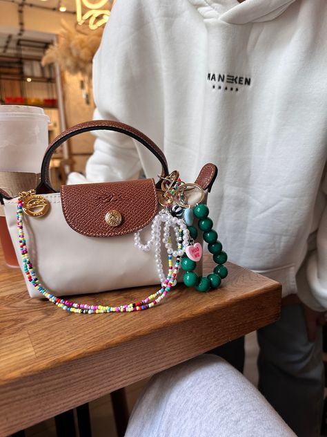 Repurpose Louis Vuitton Purses, Summer Bags Aesthetic, Purse Accessories Aesthetic, Bag With Charms Aesthetic, Decorated Purse Aesthetic, Purse With Charms, Bag Charm Trend 2024, Mini Purse Aesthetic, Bag Accessories Aesthetic