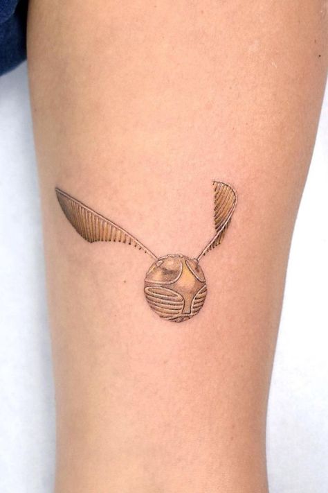 The Golden Snitch, A Harry Potter tribute tattoo made by Julian Martinez in London, UK. Quidditch Tattoo, Golden Snitch Tattoo, Snitch Tattoo, Tribute Tattoo, The Golden Snitch, Rings Tattoo, Tribute Tattoos, Harry Potter Quidditch, Movie Tattoo