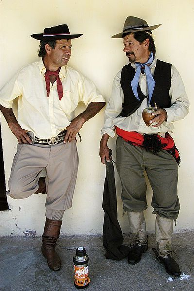 The men's clothing is a male gaucho costume combined with black trousers with a white shirt and above it an open short sleeve jacket. these garments for the basis of the ¨guacho-look¨, which also includes a series of key accessories that are required in order for the ensemble to be considered truly ¨gaucho¨. Gaucho is the style of farm life and rural culture. Uruguay Traditional Clothing, Argentina Traditional Clothing, Argentinian Culture, Folk Band, Brazilian Clothes, Argentina Food, Transitional Fashion, Folk Dresses, Peregrine