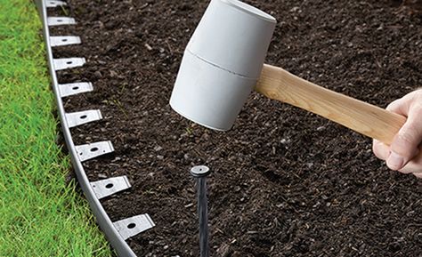 A person is pounding a stake into edging material in a flower bed. No Dig Garden, Plastic Landscape Edging, Plastic Lawn Edging, Metal Landscape Edging, Garden Border Edging, Dig Gardens, Wood Mulch, Designing Ideas, Plastic Edging