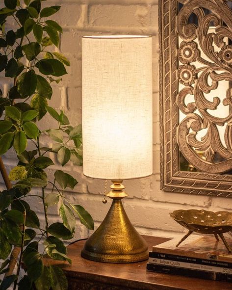 Architectural beauty in the shape of a table lamp that pays homage to a Kalash, the temple’s top spire. The Kalash lamp is hand beaten from brass sheet metal by the Thathera artisans. Find it in our stores and website. #tpt #mytpt #thepurpleturtles #newbeginnings #homedecorstyle #homedecor #interiordecor #livingspace #decorindia #interiordesign #architecture #tablelamp #pendantlight #ceilinglamp #light #glasslamp #hanginglamp #clusterlamp #lampshade #lightinstallation #lightdesign #lightdecor Indian Lamps, Indian Table, Indian Homes, Indian Decor, Eclectic Design, Light Installation, Night Lamps, The Temple, Lamps Living Room