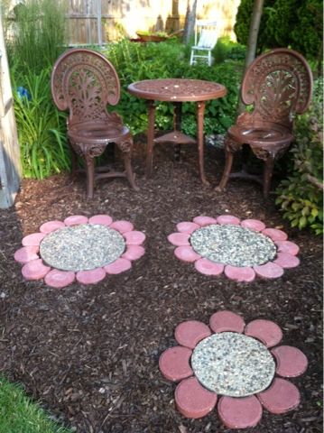 Paver Flowers - this would be fun with custom middles the kids make (same size as some of the aggregate pavers) with colored glass beads. Fun keepsake stepping stones adding a splash of color in the flower beds. Stepping Stone Flowers, Sunflower Stepping Stones Diy, Playhouse Flower Bed, Stone Flowers Garden Art, Sunflower Pavers, Fairy Stepping Stones, Cute Stepping Stone Ideas, Mulch And Paver Walkway, Rock Flower Path