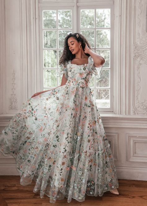 First Day of Forever Love is in full bloom. Adorned with lush embroidered florals, this exquisite gown exudes the elegance of spring. A ruched, accentuated bodice paired with flutter sleeves imbues a sense of gentle beauty. Scalloped edges at the hem and lined along the sleeves remind the wearer that love is ever in th Love Is In Full Bloom, Satin Formal Gown, Africa Trip, American Dress, Exquisite Gowns, Floral Gown, Beautiful Dress Designs, Perfect Prom Dress, Grad Dresses