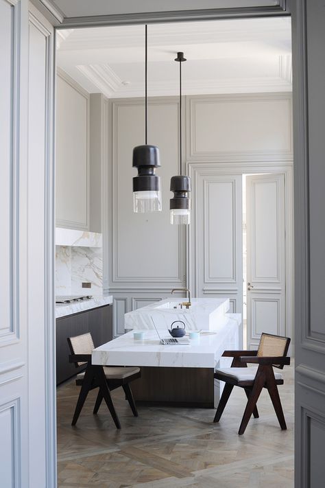 In the kitchen, all technical elements are hidden behind calacatta marble partitions. Bronze ‘Fingi’ suspension lighting by Eric Schmitt (Eric Schmitt). Office armchairs by Pierre Jeanneret (Galerie 54).  http://www.yatzer.com/joseph-dirand-saint-germain-paris // Photo © Adrien Dirand / AD France n° 119, September/October 2013. Modern French Interiors, Glamorous Kitchen, Joseph Dirand, Minimalist Dekor, Interior Dapur, Parisian Apartment, Kitchen Marble, Interior Modern, French Interior