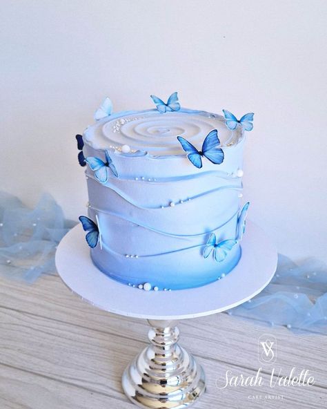 My magical creation: a stunning cake crowned with edible pearls and enchanting butterflies that will make your taste buds and imagination soar. You can check out my other creations on my website's cake gallery. Cake With Edible Butterflies, Simple Butterfly Cake Ideas, Cake Decorating Styles, Sky Blue Cake Ideas, Cake Butterfly Design, Pastel Blue Cake Aesthetic, Blue Birthday Cake Aesthetic, Butterfly Cakes Ideas, Blue Birthday Cake Ideas