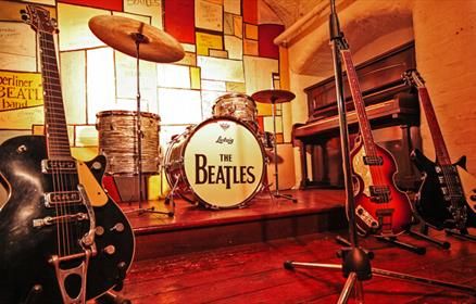 A mock up Cavern Club stage. The middle of the stage features the iconic 'The Beatles' bass drum and 3 guitars. Beatles Magical Mystery Tour, The Beatles Story, Three Course Meal, Magical Mystery Tour, Flying Lessons, The White Album, Liverpool City, Europe Tours, Experience Gifts