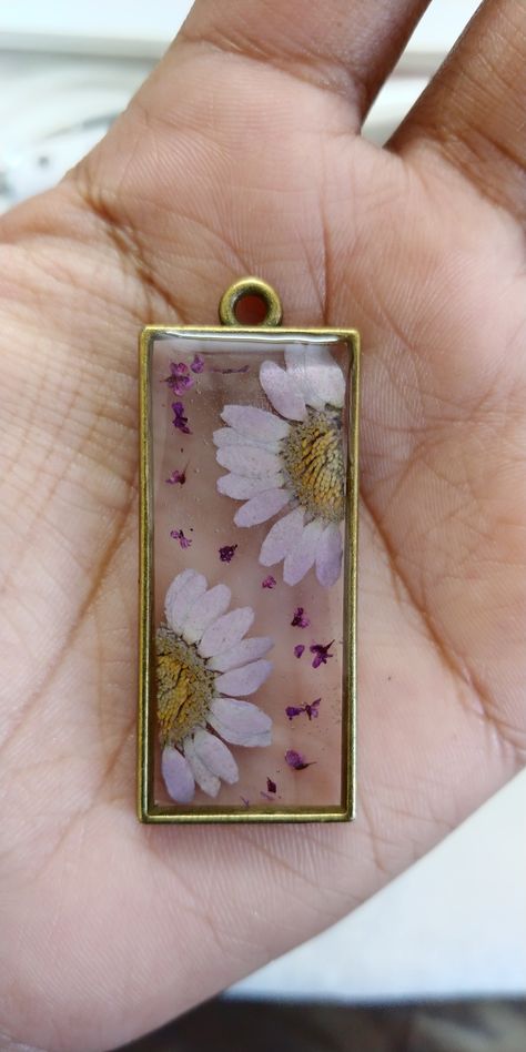 Real dried flowers, encasted in rectangle bezel frame using epoxy resin to create a resin dried flower pendent Resin Pendent Ideas, Resin Jewelry Tutorial, Pressed Flower Crafts, Pop Sockets, Resin Ideas, Easy Diy Art, Resin Flowers, Pressed Flower, Resin Pendant