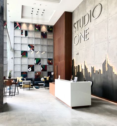 Studio One is one of the latest developments here in Dubai & it just opened it doors to its residents - designed & furnished by @EMDE_Design #urban #modern #lobby #lobbydesign #design #concrete #artwork #decor Interior Design Urban Modern, Corporate Office Entrance Design, Open Office Wall Design, Corporate Office Lobby Design, Building Lobby Design Entrance, Office Wall Ideas For Work, Reception Wall Design Modern, Office Back Wall Design Interiors, Office Reception Wall Design